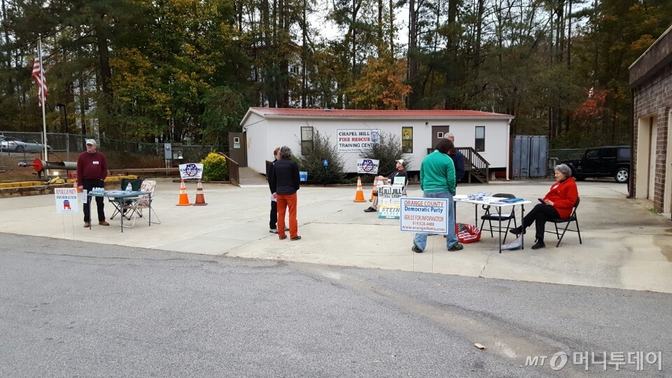 8일 미국 노스캐롤라이나 채플힐의 한 소방서에 마련된 투표소에서 공화당(맨 왼쪽)과 민주당(맨 오른쪽) 선거원들이 유권자들에게 투표 안내를 하고 있다. /사진=양영권 기자