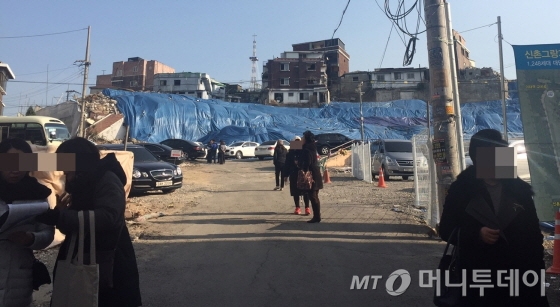 25일 공인중개소 관계자들이 신촌그랑자이 모델하우스 방문객들을 상대로 연락처를 받아내고 있다. 뒤쪽은 신촌그랑자이가 들어설 공사 현장/사진=배규민