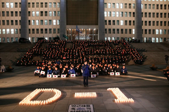 추미애 더불어민주당 대표와 우상호 원내대표를 비롯한 의원들이 8일 서울 여의도 국회의사당 본청 앞에서 열린 박근혜 대통령 탄핵 촉구 촛불집회에서 촛불을 들고 '탄핵과 D-1' 글자를 밝히고 있다. /뉴스1