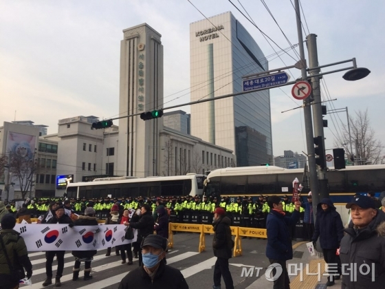 24일 오후 '대통령 탄핵기각을 위한 국민총궐기 운동본부'(탄기국) 집회 참여자와 촛불집회 측 충돌에 대비해 경찰이 서울시청 부근에 경찰 인간 띠를 만들고 차벽(경찰 차량) 2대를 세웠다. /사진=방윤영 기자