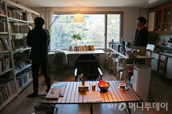 '남의 집 도서관'을 찾은 손님들에게 직접 책을 설명하고 추천해주는 김성용씨(오른쪽)/ 사진=박다해 기자