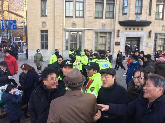 지난달 25일 촛불집회를 앞두고 광화문사거리에서 태극기 집회 참가자와 촛불집회 참가자 간 가벼운 몸싸움이 벌어졌다. 위쪽 태극기측 참가자를 경찰이, 아래쪽 촛불 측 참가자를 집회 참가자들이 다독이고 있다./사진=우경희 기자