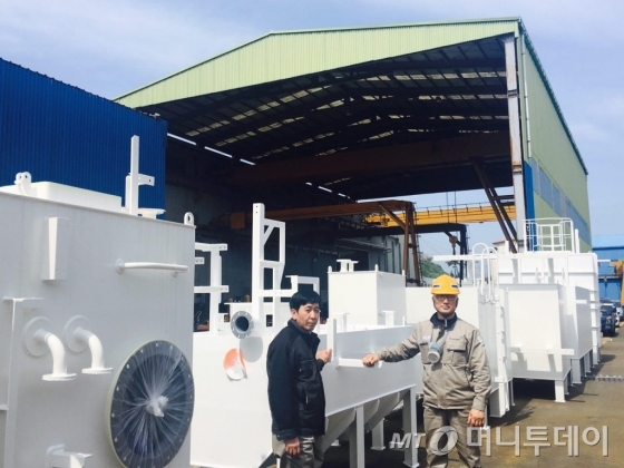 박상진 한창 대표(왼쪽)가 직원가 선행도장을 완료한 선박 부품 앞에 서있다./사진=김하늬