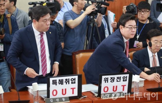 새누리당 김선동, 김성원 의원이 2일 오전 서울 여의도 국회 정무위원회에서 열린 김상조 공정거래위원장 후보자 인사청문회에서 '특혜취업 OUT', '위장전입 OUT'이라고 적힌 피켓이 붙어 있는 자리에 앉고 있다./사진=이동훈 기자
