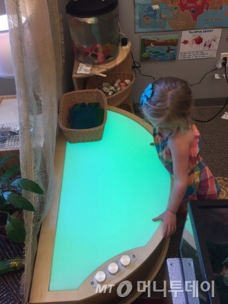 13일(현지시간)  미국 아이오와주 사이언스 센터(science center) 유치원에서 어린이가 라이트 테이블(빛이 나오는 테이블)을 조작하며 놀고 있다. 버튼을 조절해서 빛 색깔을 바꿔보는 놀이다. 아이는 이 놀이를 통해 빛의 변화를 배울 수 있다./사진=아이오와(미국)=방윤영 기자