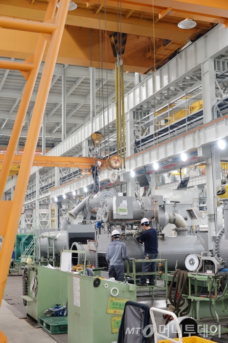 LG전자 직원들이 27일 평택 칠러 사업장에서 터보 칠러를 생산하고 있다. 대형 크레인이 열교환기와 결합시키기 위해 압축기를 들어 올려 이동시키고 있다/사진제공=LG전자