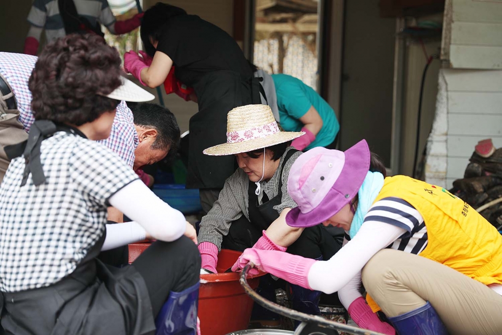 문재인 대통령 부인 김정숙 여사가 21일 충북 청주 상당구 미원면 운암2리 청석골 마을을 찾아 폭우 피해로 젖은 가재도구를 정리하고 빨래를 하며 복구 작업을 돕고 있다. (청와대) 2017.7.21/뉴스1