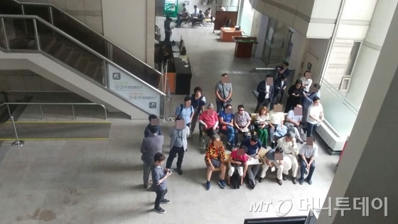 서울중앙지방법원 방문객들이 법원 로비에 마련된 TV 보도를 지켜보고 있다/사진=김성은 기자