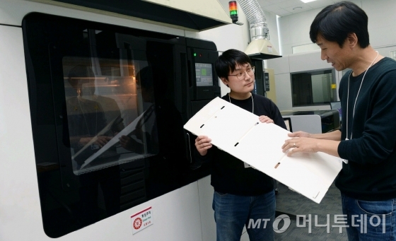 LG전자는 제품 개발단계에서 제품 외관을 디자인하거나 신규 부품을 적용하는데 3D프린터를 사용해 제품 모형을 제작한다. 장비 도입 전과 비교하면 모형을 만드는 데 걸리는 시간이 약 30% 줄었고, 비용 절감도 연간 7억원에 이른다. LG전자 연구원들이 3D프린터로 만들어낸 냉장고 부품을 살펴보고 있다/사진제공=LG전자