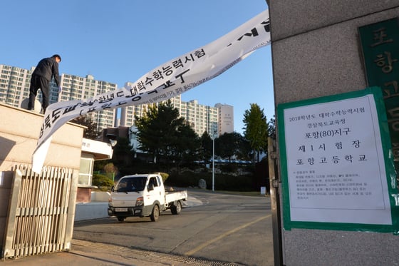 경북 포항시를 덮친 진도 5.4규모의 지진 발생 이틀째인 16일 2018학년도 수능시험 포항지역 1고사장인 포항고등학교 교문에 걸려있던 수능시험장 안내 현수막이 철거되고 있다.교육부는 지진과 관련 수능시험을 일주일 후인 23일로 연기했다. /사진=뉴스1