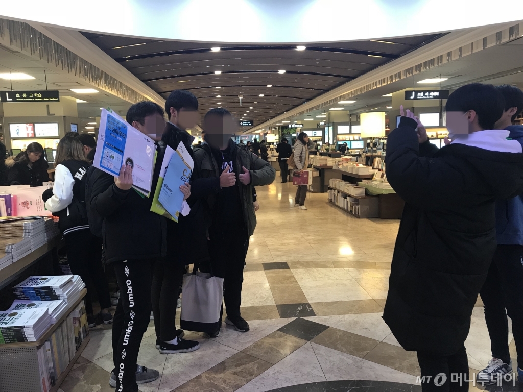 연기된 수능에 새로운 참고서를 구입한 수험생들이 인증사진을 찍고있다./사진=신현우 기자