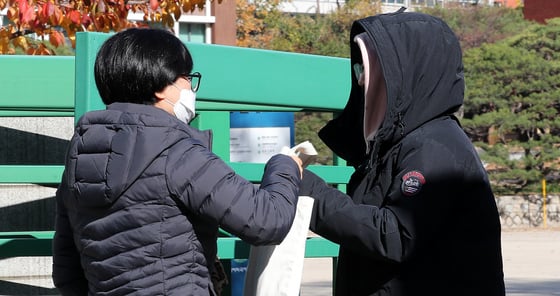 포항지진 여파로 대학수학능력시험이 일주일 연기됐다. 16일 서울 서대문구 이화여자외국어고등학교에서 한 학부모가 딸에게 도시락을 전해주고 있다./사진=뉴스1