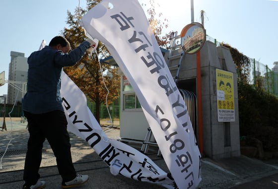 16일 오전 부산 해운대구 좌동 신도고등학교 관계자들이 수능시험장 안내문을 내리고 있다/사진=뉴스1