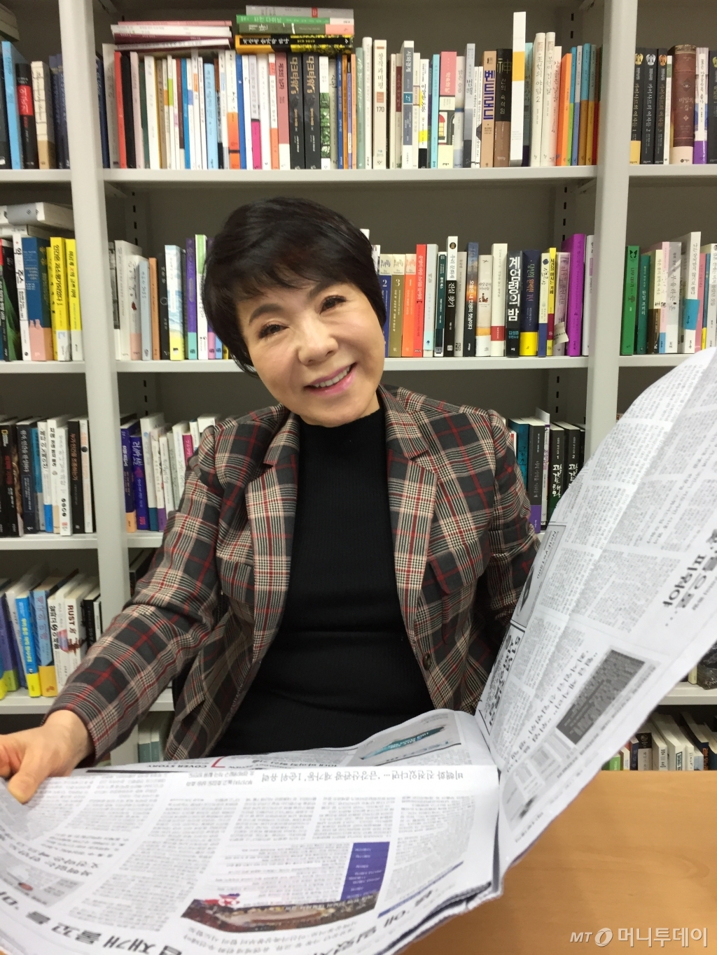 가수 최진희가 늦은 인터뷰 시간에도 머니투데이 신문을 펼쳐 뉴스를 확인한 뒤 활짝 웃으며 자신의 음악 인생 이야기를 풀어놓고 있다. /사진=김고금평 기자