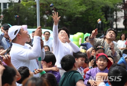 【서울=뉴시스】전신 기자 = 문재인 대통령 부인 김정숙 여사가 5일 청와대 녹지원에서 열린 2018 어린이날 청와대 초청행사에서 어린이들과 함께 박 터뜨리기를 하고 있다. 2018.05.05.   photo1006@newsis.com
