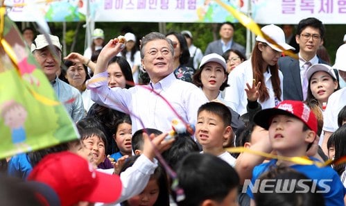 【서울=뉴시스】전신 기자 = 문재인 대통령이 5일 청와대 녹지원에서 열린 2018 어린이날 청와대 초청행사에서 어린이들과 함께 박 터뜨리기를 하고 있다. 2018.05.05.   photo1006@newsis.com