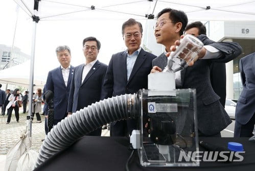 문재인 대통령이 지난 17일 서울 마곡 R&D 단지에서 열린 혁신성장 점검회의에 앞서 현대차 관계자의 설명을 들으며 수소전기버스 미세먼지 저감 체험을 하고 있다./사진=뉴시스