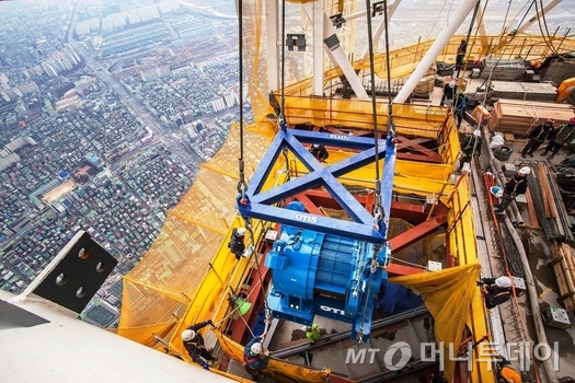 오티스가 롯데월드타워 최상부에 권상기를 설치하는 모습./사진제공=오티스