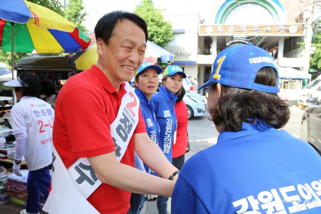 정창수 자유한국당 강원지사 후보가 5일 철원 동송시장에서 더불어민주당 선거운동원과 악수를 하고 있다./사진=김민우 기자