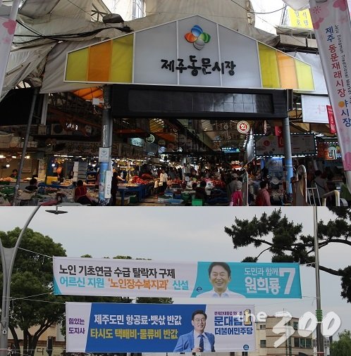 제주동문시장(사진 위) 모습과 그 앞에 걸린 더불어민주당 문대림·무소속 원희룡 제주도지사 후보의 현수막 모습(사진 아래). /사진=이건희 기자