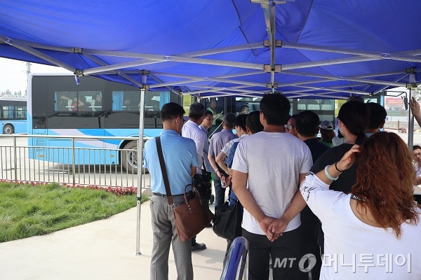 지난 4월1일 준공한 슝안시민서비스센터로 가는 셔틀버스를 기다리는 사람들/사진=진상현 베이징 특파원.