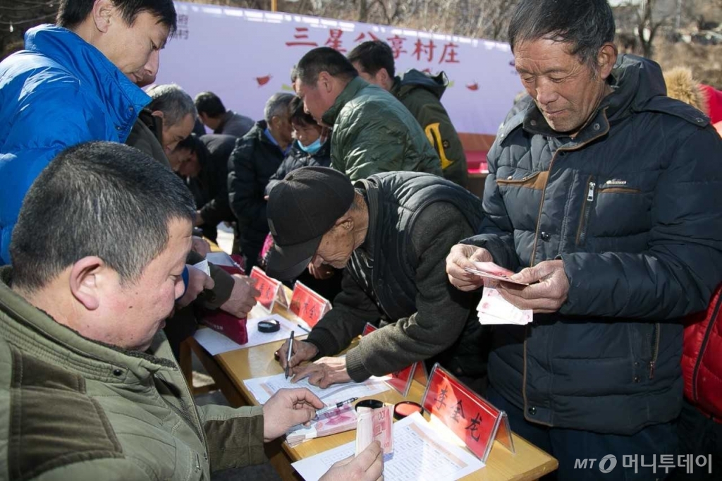 지난 1월 진행된 중국 허베이성 난위촌 농촌합작사의 배당금회의에서 마을 주민들에게 배당금이 지급되고 있다./사진제공=중국삼성