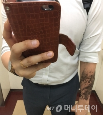 때밀이 타올에 비누를 묻혀 타투를 지워내고 있다. 힘을 줘서 밀자 조금씩 지워졌다./사진=남형도 기자
