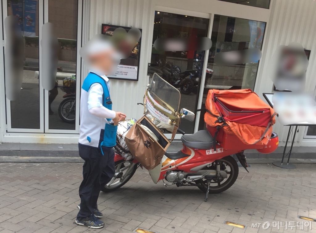 한 호텔 안내직원이 모자를 벗고 땀방울을 훔친 뒤 다시 옷매무새를 정돈하고 있다./사진=남형도 기자