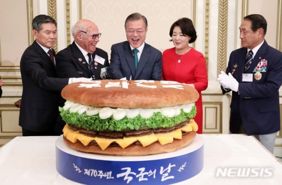 【서울=뉴시스】전신 기자 = 문재인 대통령이 1일 청와대 영빈관에서 열린 제70주년 국군의 날 경축연에서 대형 햄버거를 자르고 있다. 왼쪽부터 정경두 국방부 장관, 유엔군 참전 용사인 혹스워스 영국 예비역 육군하사, 문 대통령, 김정숙 여사, 김진호 재향군인회장. 2018.10.01. photo1006@newsis.com <저작권자ⓒ 공감언론 뉴시스통신사. 무단전재-재배포 금지.>