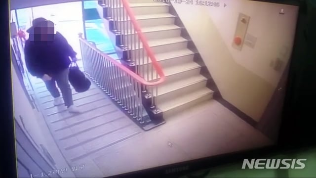 부산 사하구 일가족 살해 용의자로 추정되는 남성이 범행도구가 들어 있는 것으로 추정되는 큰 가방을 들고 아파트로 들어가는 모습이 담긴 CCTV영상. /사진=부산경찰청