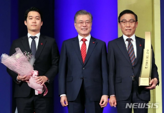 【서울=뉴시스】전신 기자 = 문재인 대통령이 7일 서울 삼성동 코엑스에서 열린 제55회 무역의 날 기념식에서 김기남 삼성전자 대표이사에게 900억불 수출의 탑을 수여한 뒤 기념촬영을 하고 있다. 2018.12.07.   photo1006@newsis.com  <저작권자ⓒ 공감언론 뉴시스통신사. 무단전재-재배포 금지.>