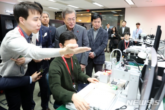 【서울=뉴시스】전신 기자 = 문재인 대통령이 3일 서울 중구 서울스퀘어에 위치한 전문형 메이커 스페이스인 엔피프틴(N15)을 방문해 스타트업 기업 아티슨앤오션이 스마트폰을 연동한 스쿠버다이빙 장비를 3D 모델링 출력을 통해 제작하는 과정과 외관 및 전자부품 제작시연을 지켜보고 있다. 메이커 스페이스는 전문적 생산 장비를 보유하지 않아도 자신의 아이디어를 실물로 만들어볼 수 있도록 설비를 갖춰놓은 작업 공간으로 3D프린터, 레이저 가공기 등 디지털 기기를 이용해 빠르게 완제품을 만들 수 있다. 2019.01.03. photo1006@newsis.com <저작권자ⓒ 공감언론 뉴시스통신사. 무단전재-재배포 금지.>