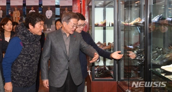 【서울=뉴시스】전신 기자 = 문재인 대통령이 3일 서울 성동구 성수 수제화 희망플랫폼을 방문해 유홍식 드림제화 대표, 정원오 성동구청장에게 희망플랫폼 1층 쇼룸에 전시된 수제화에 대해 설명을 듣고 있다. 2019.01.03.   photo1006@newsis.com  <저작권자ⓒ 공감언론 뉴시스통신사. 무단전재-재배포 금지.>