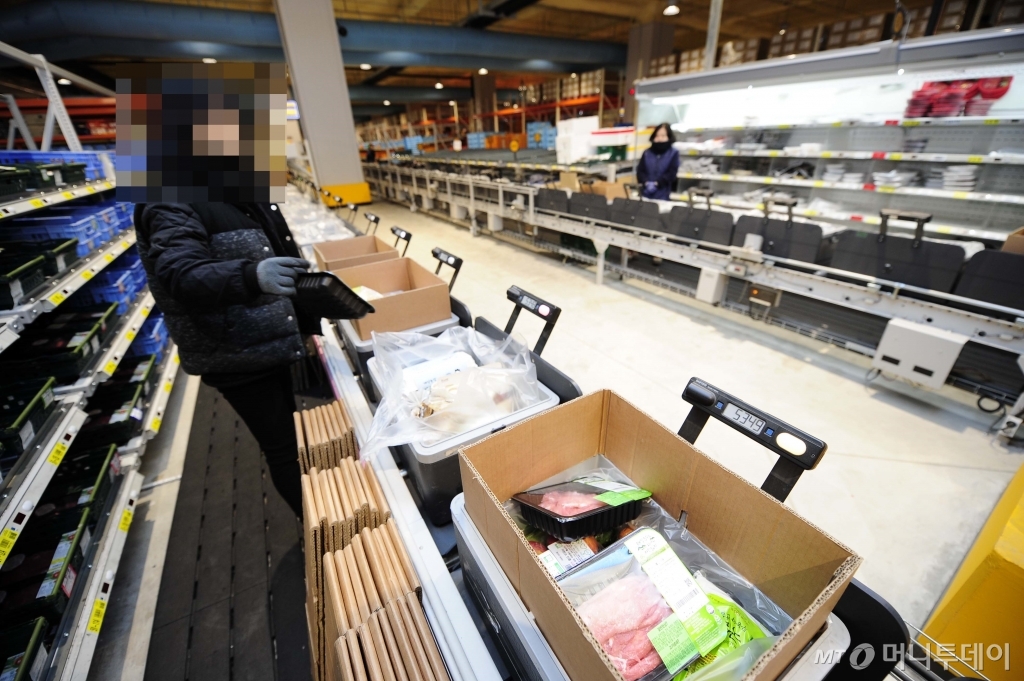 이마트 네오 김포센터 직원들이 컨베이어벨트위 바구니에 고객이 주문한 신선식품과 상품을 옮기고 있다. /사진=이마트