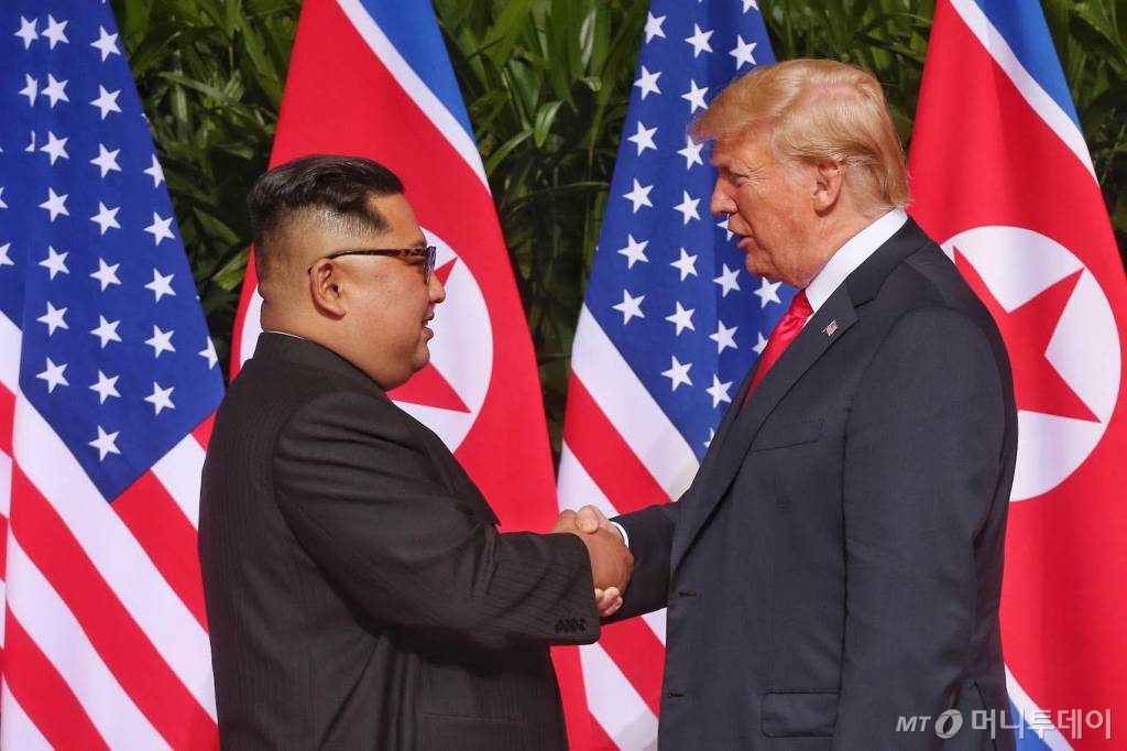 【서울=뉴시스】 역사적 첫 북미정상회담이 열린 12일 오전 싱가포르 센토사 섬의 카펠라 호텔에서 김정은 북한 국무위원장과 도널드 트럼프 미국 대통령이 회담에 앞서 악수를 나누고 있다. 2018.06.16. (사진=싱가포르 통신정보부 제공)  photo@newsis.com   <저작권자ⓒ 공감언론 뉴시스통신사. 무단전재-재배포 금지.>