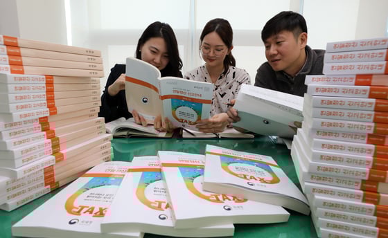 (서울=뉴스1) 이종덕 기자 = 14일 국세청 종로세무서 직원들이 세무서 법인납세과에서 오는 15일 연말정산간소화서비스 개통을 앞두고 연말정산 신고안내 책자를 검토하고 있다. 2018년 귀속 근로소득 연말정산에는 신용카드 소득공제 중 도서공연비 항목이 신설됐고, 중소기업 취업자 소득세 감면 확대, 세액공제 중 중증 질환자 세액공제가  확대되었다.2019.1.14/뉴스1  <저작권자 © 뉴스1코리아, 무단전재 및 재배포 금지>