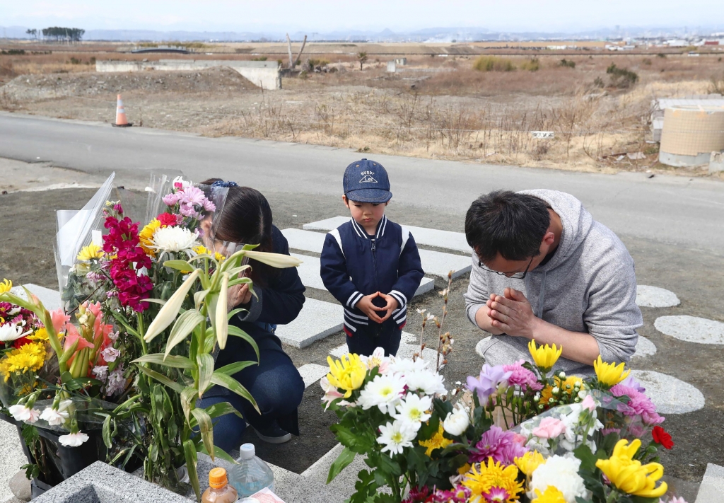 일본 도호쿠(東北) 대지진 발생 8주년을 하루 앞둔 지난 10일 일본 미야기현 센다이시에 있는 도호쿠 대지진 추모탑 앞에서 한 가족이 희생자를 위해 기도하고 있다. /AFPBBNews=뉴스1