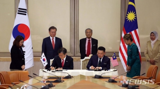 성윤모 산업통상자원부 장관과 다렐 레이킹(Darell Leiking) 말레이시아 국제통상산업부 장관이 13일 푸트라자야 총리실에서 문재인 대통령과 마하티르 모하마드 총리가 지켜보는 가운데 한-말레이시아 제조업 4.0 대응을 위한 산업협력 MOU를 체결하고 있다. 2019.03.13.【푸트라자야(말레이시아)=뉴시스】전신 기자 =   photo1006@newsis.com