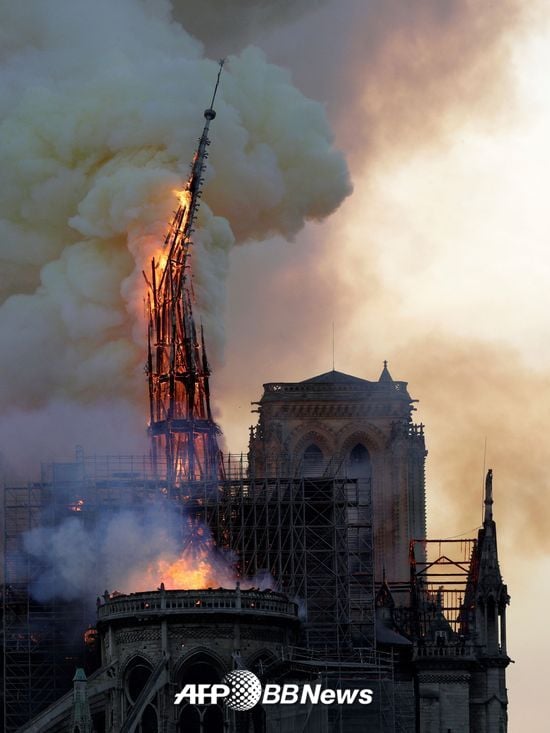 15일 오후 6시50분(현지시간)쯤 파리 구도심 내 시테섬에 있는 노트르담 대성당 화재로 불에 탄 첨탑이 무너지고 있다./사진= AFPBBNews=뉴스1