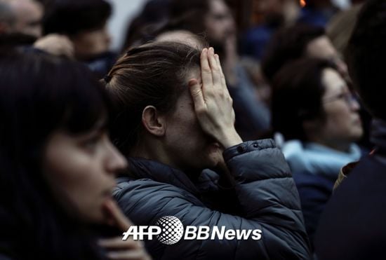 15일 오후 6시50분(현지시간)쯤 파리 구도심 내 시테섬에 있는 노트르담 대성당 화재를 보며 한 시민이 안타까워하고 있다./사진= AFPBBNews=뉴스1