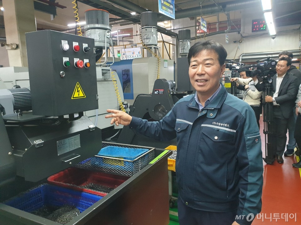 문길주 우림하이테크 대표가 스마트공장 구축을 위해 도입한 기계 앞에서 생산 과정을 설명하고 있다.