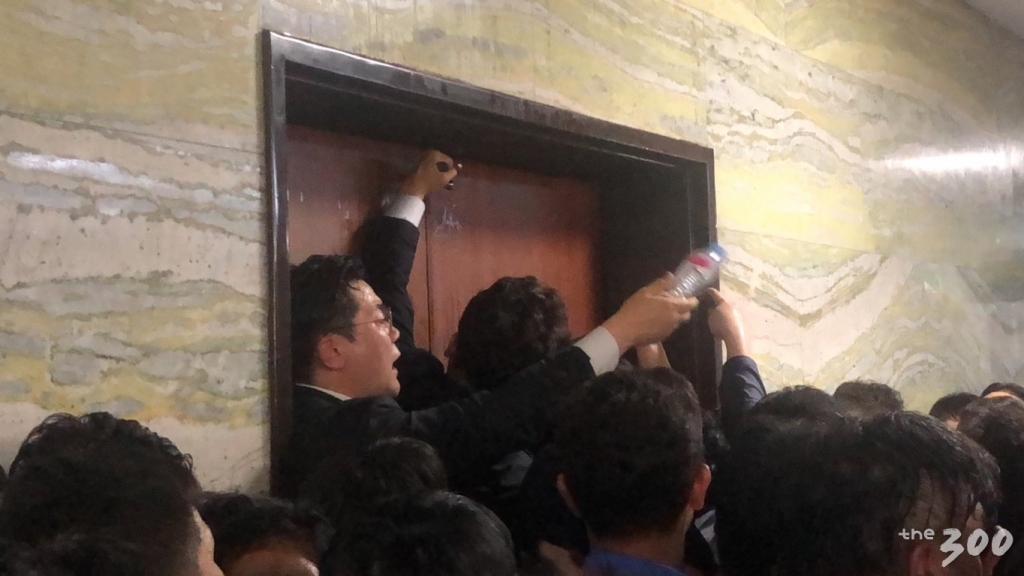 26일 새벽 2시30분쯤 더불어민주당 인사들이 국회 본청 7층 의안과 진입을 위해 망치 등 연장을 이용해 의안과 문을 강제로 여는 장면/사진=이재원 기자