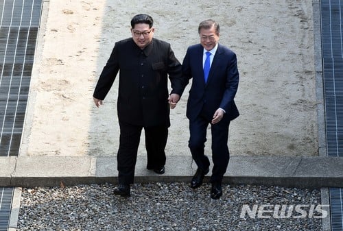 【판문점=뉴시스】전신 기자 = 2018 남북정상회담이 열린 27일 경기도 파주시 판문점에서 문재인 대통령이 북한 김정은 국무위원장의 손을 잡고 군사분계선을 넘어 북측 지역에갔다 다시 남측지역으로 향하고 있다. 2018.04.27.  photo1006@newsis.com   <저작권자ⓒ 공감언론 뉴시스통신사. 무단전재-재배포 금지.>
