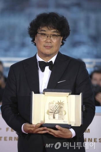 【칸=AP/뉴시스】봉준호 감독이 25일(현지시간) 프랑스 칸에서 열린 제72회 칸 국제영화제시상식에서 영화 '기생충'으로 '황금종려상'을 받고 포즈를 취하고 있다.   한국 영화가 칸영화제 최고 상인 황금종려상을 받은 것은 사상 처음으로 봉준호 감독은 "함께한 위대한 배우들이 없었다면 한 장면도 찍을 수 없었을 것"이라고 배우들에게 고마움을 전했다.   봉 감독은 '괴물'(2006, 감독주간) '도쿄!'(2008, 주목할 만한 시선) '마더'(2009, 주목할 만한 시선) '옥자'(2017, 경쟁)에 이어 5번째로 칸에 입성해 상을 받았다. 2019.05.26.
