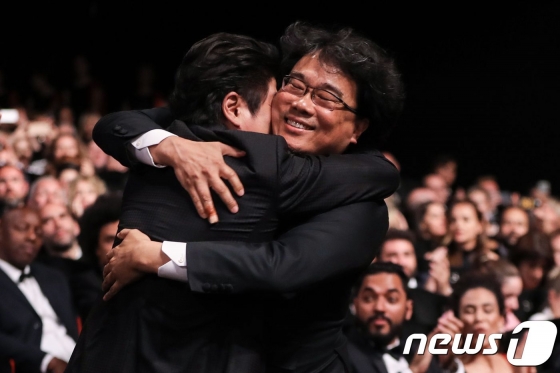 (AFP=뉴스1) 포토공용 기자 = 봉준호 감독이 25일(현지시각) 프랑스 칸 뤼미에르 극장에서 열린 제72회 칸국제영화제(칸영화제) 폐막식에서 최고상인 황금종려상을 수상한 후 배우 송강호와 포옹을 하고 있다.