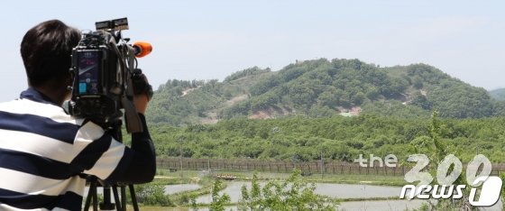 (철원=뉴스1) 사진공동취재단 = 22일 강원도 철원군 'DMZ 평화의 길'을 방문한 취재진이 화살머리 고지를 카메라에 담고 있다.   정부는 지난달 27일 고성 구간을 1차로 개방한 데 이어 오는 6월 1일부터 철원 구간을 민간에 개방하기로 하고 20일부터 참가자 신청을 받는다고 밝혔다.   이번에 개방되는 철원 구간은 15㎞이며, 차량과 도보로 이동하는 데 3시간 정도가 걸린다. 2019.5.22/뉴스1  <저작권자 © 뉴스1코리아, 무단전재 및 재배포 금지>
