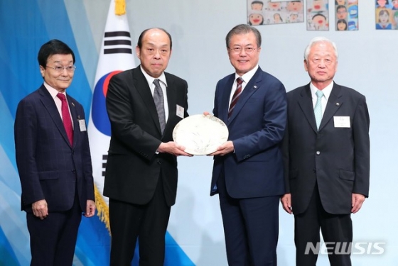 【오사카(일본)=뉴시스】전신 기자 = 문재인 대통령이 27일 오사카 뉴오타니 호텔에서 열린 동포 만찬간담회에서 제15대 심수관씨로부터 사츠미 난화도 접시를 선물받고 있다. 2019.06.27.   photo1006@newsis.com