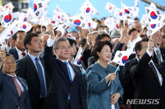 【서울=뉴시스】전신 기자 = 문재인 대통령과 부인 김정숙 여사가 지난해 8월15일 서울 용산구 국립중앙박물관 열린마당에서 열린 제73주년 광복절 및 정부수립 70주년 경축식에서 태극기를 흔들고 있다. 2018.08.15.   photo1006@newsis.com  <저작권자ⓒ 공감언론 뉴시스통신사. 무단전재-재배포 금지.>