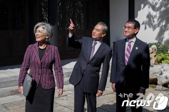 (베이징 AFP=뉴스1) 우동명 기자 = 강경화 외교부 장관이 21일(현지시간) 베이징 구베이 타운에서  한중일 외교장관 회의에 앞서 왕이 중국 외교 담당 국무위원 겸 외교부장, 고노 다로 일본 외무상과 얘기를 나누고 있다.   © AFP=뉴스1  <저작권자 © 뉴스1코리아, 무단전재 및 재배포 금지>