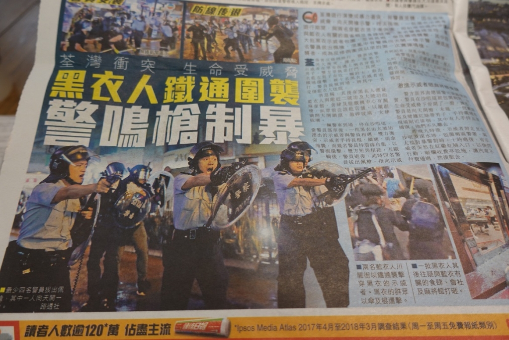 시위대를 향해 실탄이 장전된 권총을 겨눈 홍콩 경찰 사진을 1면에 실은 현지 신문. /사진=유희석